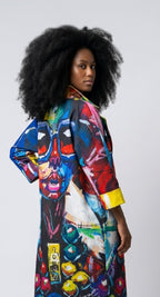Woman wearing a colorful, art-inspired kimono style  coat against a plain background